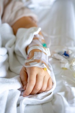 Woman's hand piercing needle to give saline solution