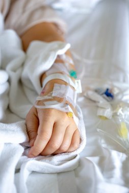 Woman's hand piercing needle to give saline solution