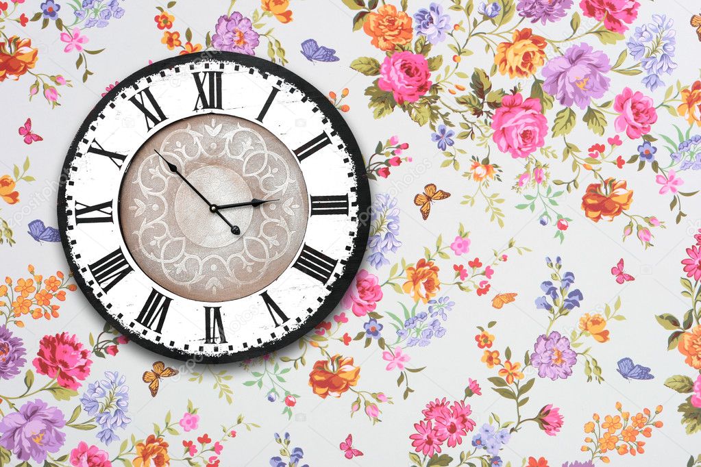 Wooden retro clock on floral wallpaper