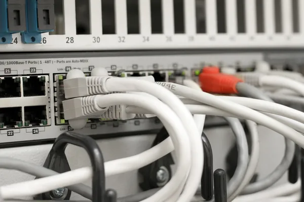 Network hub and cables connected to servers in a datacenter — Stock Photo, Image