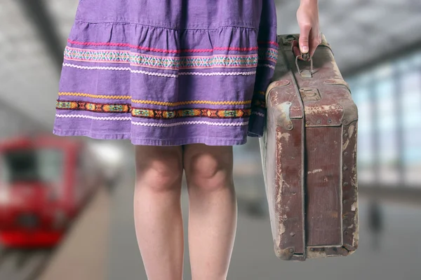 Flicka med en retro resväska på stationen — Stockfoto