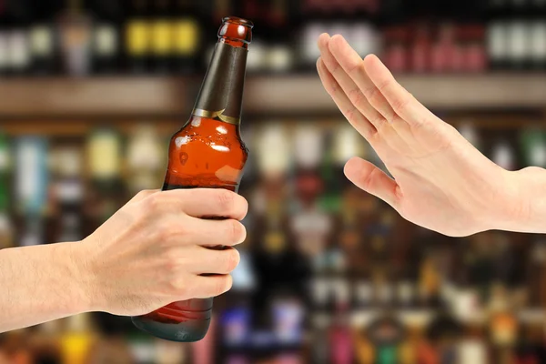 Hand weigeren een flesje bier in de bar Stockfoto