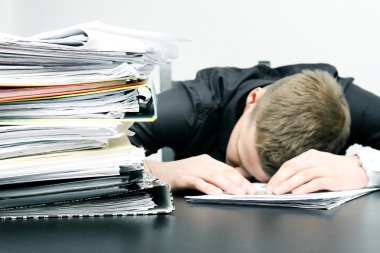 yorgun ofis çalışanı ve bir yığın belgelerine