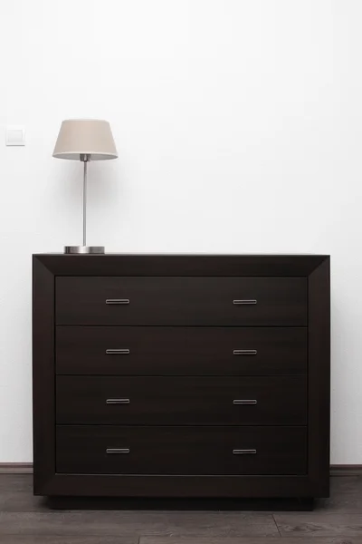 Commode marrom com lâmpada no interior minimalismo brilhante — Fotografia de Stock