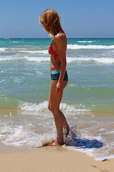 Jovem mulher andando na praia de areia — Fotografia de Stock