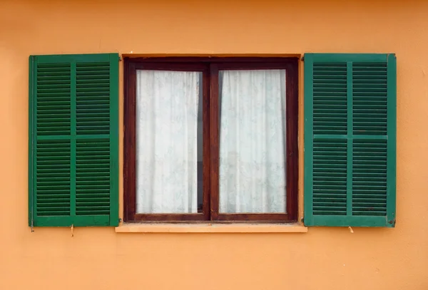 Grüne Fensterläden an gelber Hausfassade geöffnet — Stockfoto