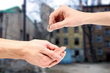 Hand gives coin to beggar on the street clipart