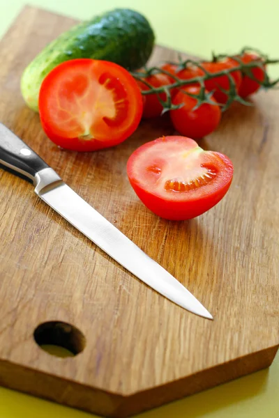 Vegetables and knife on wooden cutting board — Stock Photo, Image