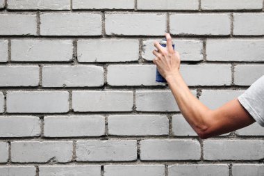 grafiti sprey olabilir tuğla duvarın önünde tutan el