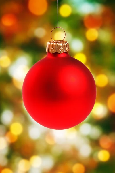 Rote Weihnachtskugel hängt auf buntem Bokeh-Hintergrund — Stockfoto