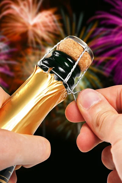 Ouverture du champagne avec feux d'artifice en arrière-plan — Photo