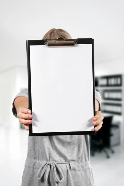 Mulher segurar uma área de transferência em branco no escritório — Fotografia de Stock