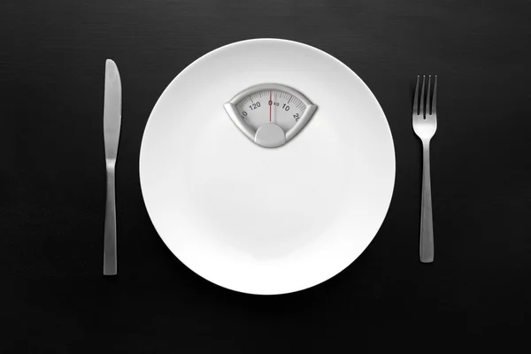 Conceito de dieta - placa branca com balança de peso — Fotografia de Stock