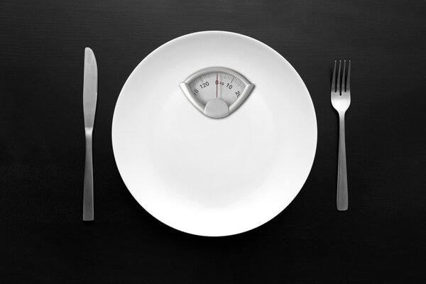 dieting concept - white plate with weight scale