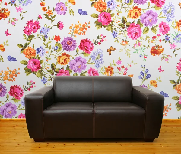 Interior com sofá de couro marrom contra parede floral colorida — Fotografia de Stock