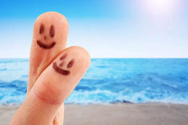 Fingertoppar med leende ansikten på stranden — Stockfoto