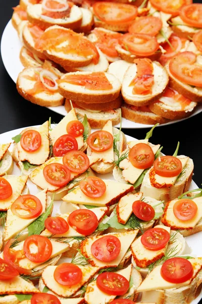 Verschiedene leckere Vorspeisen mit Käselachs und Tomaten — Stockfoto