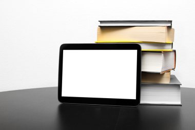 boş dijital tablet ve kitap yığını