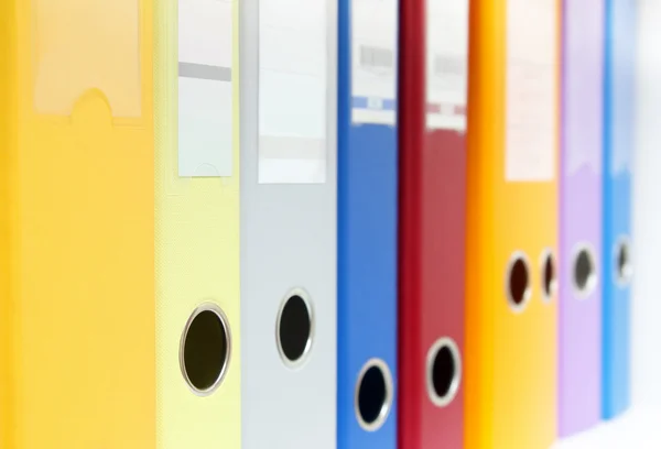 Row of colorful ring binders on shelf — Stock Photo, Image