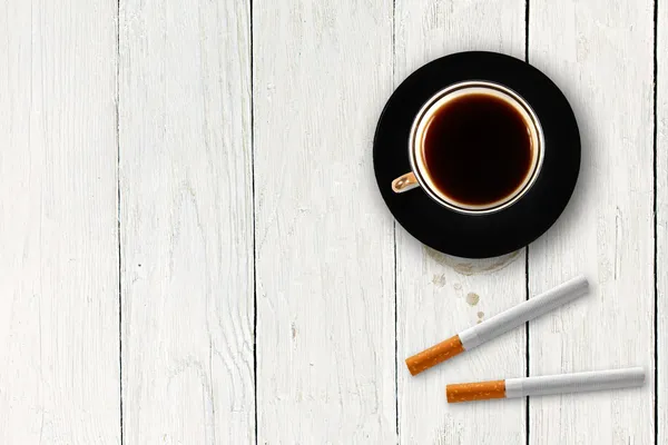 Φλιτζάνι καφέ με τσιγάρα στο ξύλινο τραπέζι — Φωτογραφία Αρχείου