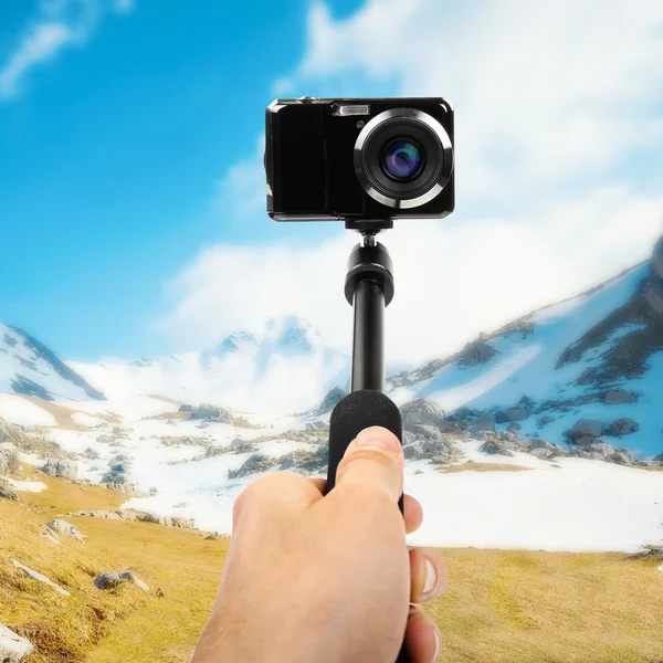 Taking selfie - hand hold monopod with photo camera — Stock Photo, Image