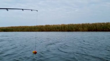 Gölün arka planında asılı duran bir olta.