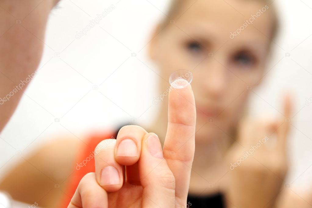 woman with contact lens on her finger