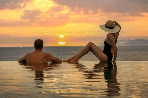 蜜月假期 一对情侣在豪华度假胜地的无限大池中享受浪漫的日落 — 图库照片