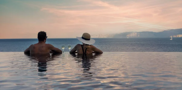 这对情侣享受着浪漫的海景 在豪华度假胜地的无边游泳池里喝着香槟 横幅复制空间 — 图库照片