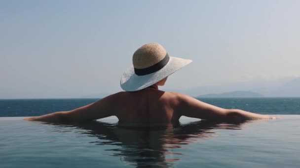 Mulher Com Chapéu Palha Relaxante Piscina Infinita Com Vista Para — Vídeo de Stock