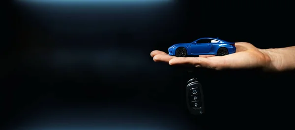 Hand Holding Miniature Automobile Model Key Dark Background Car Buying Stockafbeelding