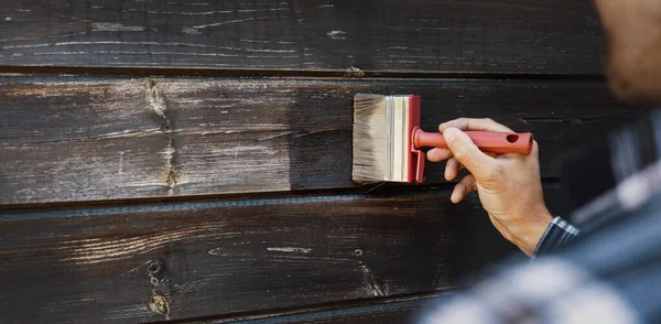 家の外の木製の側面の改装 古い木の板の絵を復元する男 — ストック写真