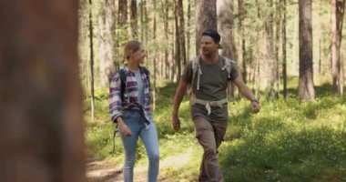 young couple with backpacks on a walk in forest. backpacking trip, summer adventure hike