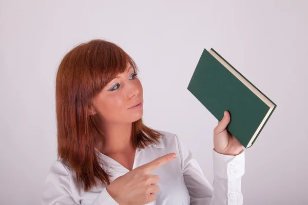 Uma jovem mulher bonita está segurando um livro — Fotografia de Stock
