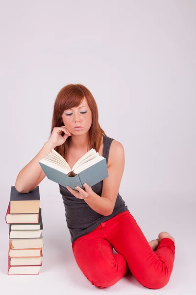 Una joven mujer hermosa está leyendo un libro — Foto de Stock