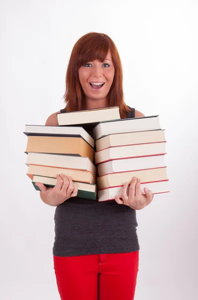 Een mooie jonge vrouw is het dragen van een heleboel boeken — Stockfoto