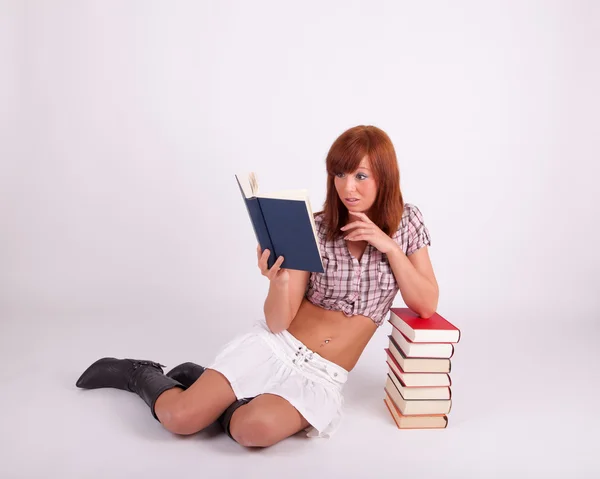 Una giovane bella donna sta leggendo un libro — Foto Stock