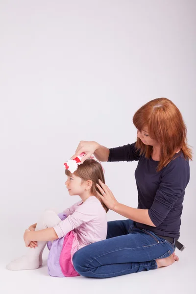 A mother is brushing her daughters hair — Stock Photo, Image