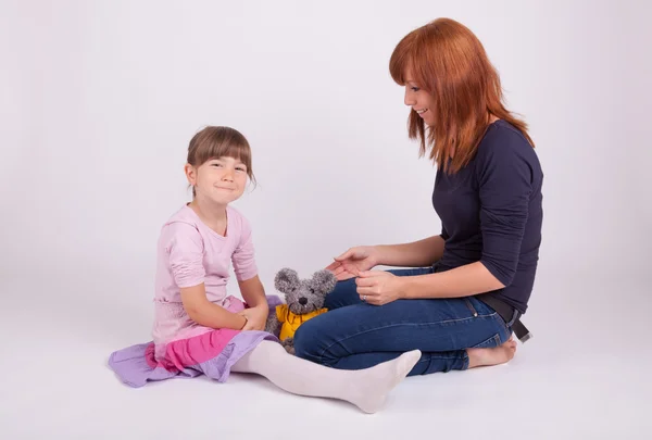 Mother and daughter are playing with a plush toy — Stock Photo, Image