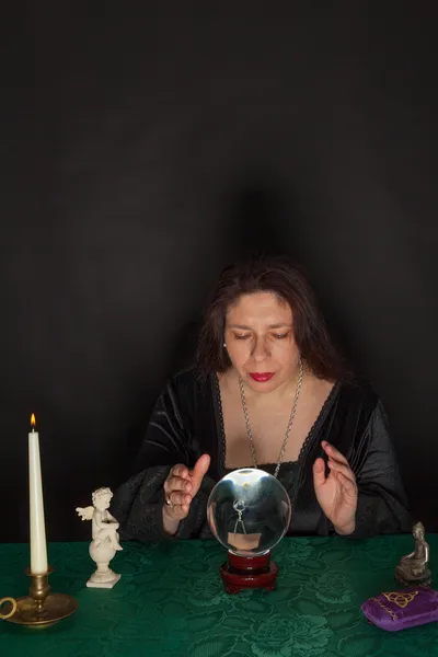 Een vrouw is op zoek naar een kristallen bol — Stockfoto