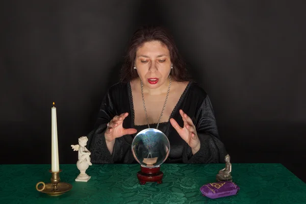 A woman is looking into a crystal ball — Stock Photo, Image