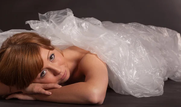 La giovane donna è avvolta in un foglio di alluminio sul pavimento — Foto Stock