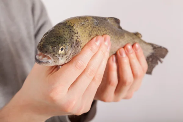 A man has a fish in his hand — Stock Photo, Image