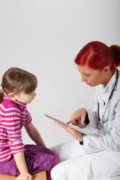 The pediatrician writes her report on a tablet PC — Stock Photo, Image
