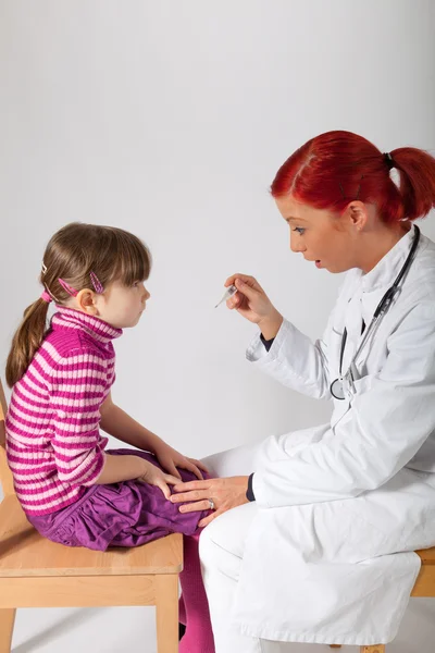 The pediatrician has a thermometer in hand — Stock Photo, Image
