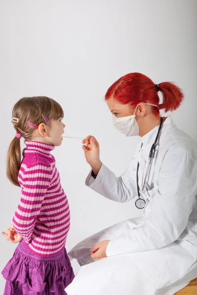 Le pédiatre regarde une petite fille dans la bouche — Photo
