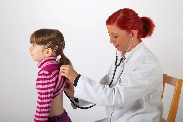 The pediatrician listens on a little girl — Stock Photo, Image