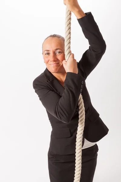 Die junge Frau klettert ein dickes Seil hinauf — Stockfoto