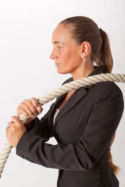 Eine junge Frau zieht an einem dicken Seil — Stockfoto