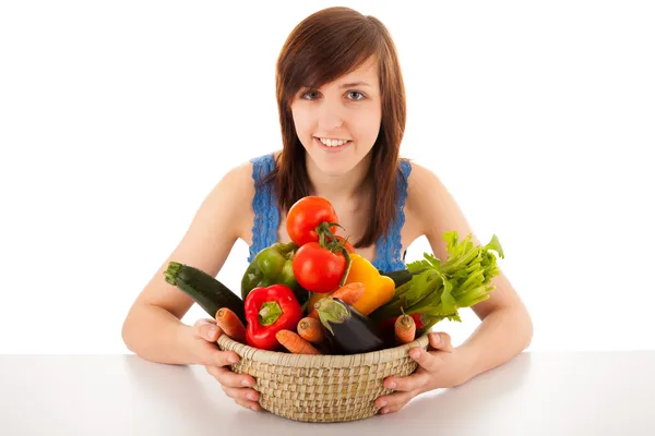 Une jeune femme avec un panier plein de légumes — Photo